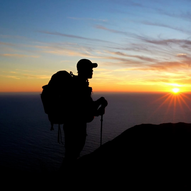 Alex Godard au sommet d'une montagne au lever du soleil