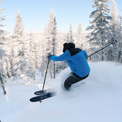 Man skiing downhill in powder snow