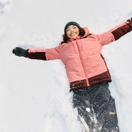 Femme couchée dans la neige avec habit de neige Chlorophylle