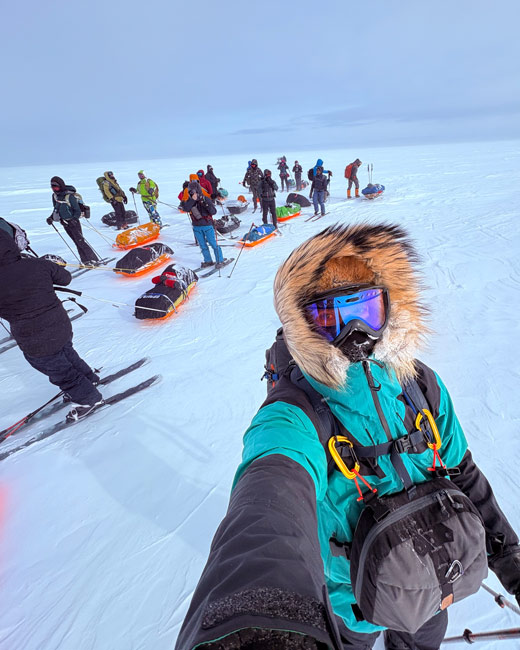 Un homme prend un autoportrait avec un groupe de skieurs posant ensemble sur le lac Saint‑Jean enneigé.