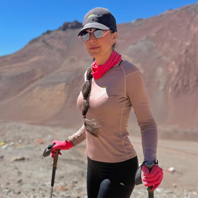 Marie-Pier Desharnais en randonnée au Chili, portant des vêtements de plein air Chlorophylle, marchant dans un paysage montagneux.