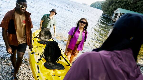 Four people heading out kayaking, wearing Chlorophylle sun‑protective clothing.