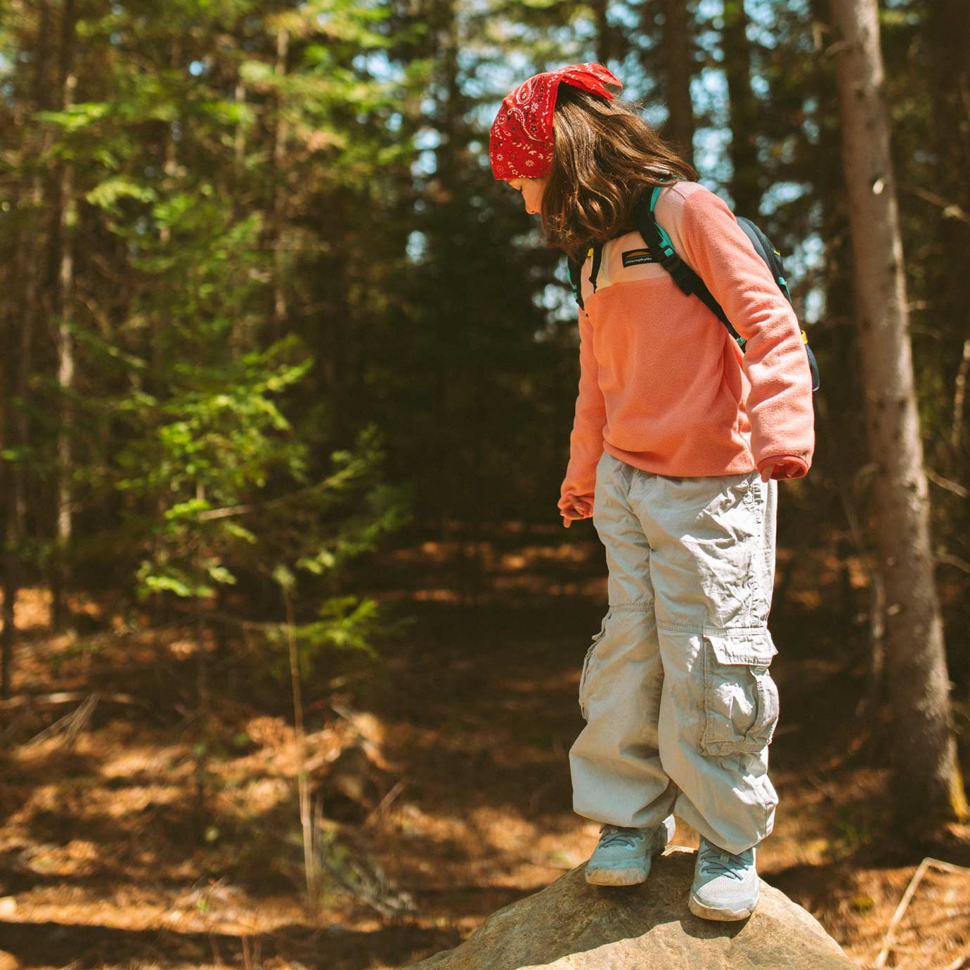 Jeune fille en forêt vêtue d'un polar rose de Chlorophylle