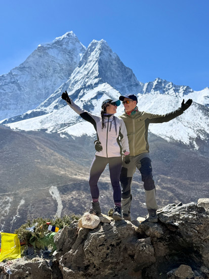 A couple posing together with the majestic Himalayan mountains in Nepal in the background